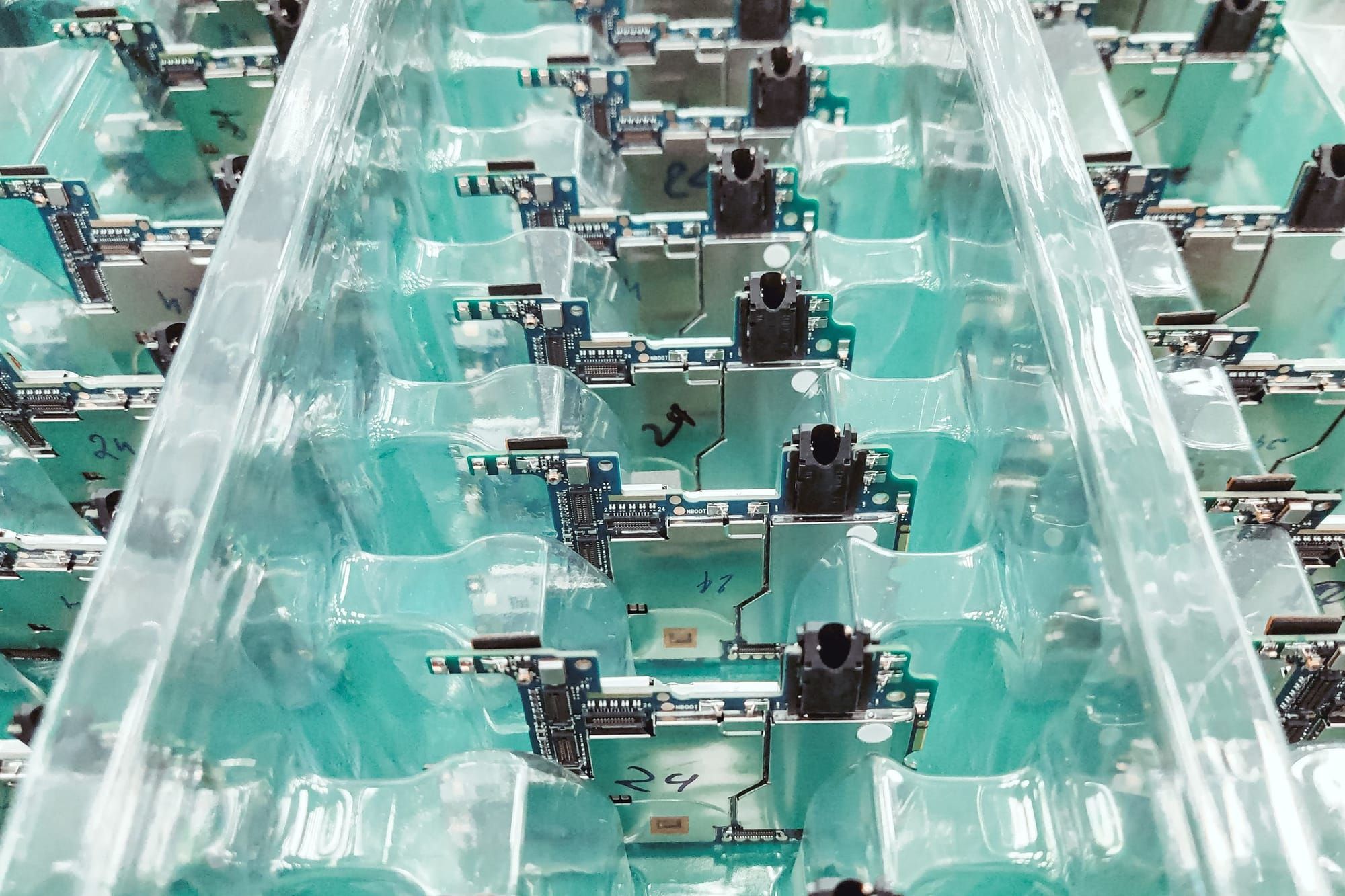 Circuit boards in trays moving along an assembly conveyor