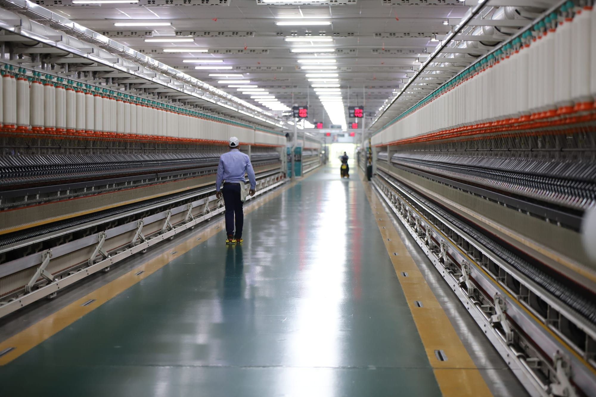 A long aisle between rows of textile machines