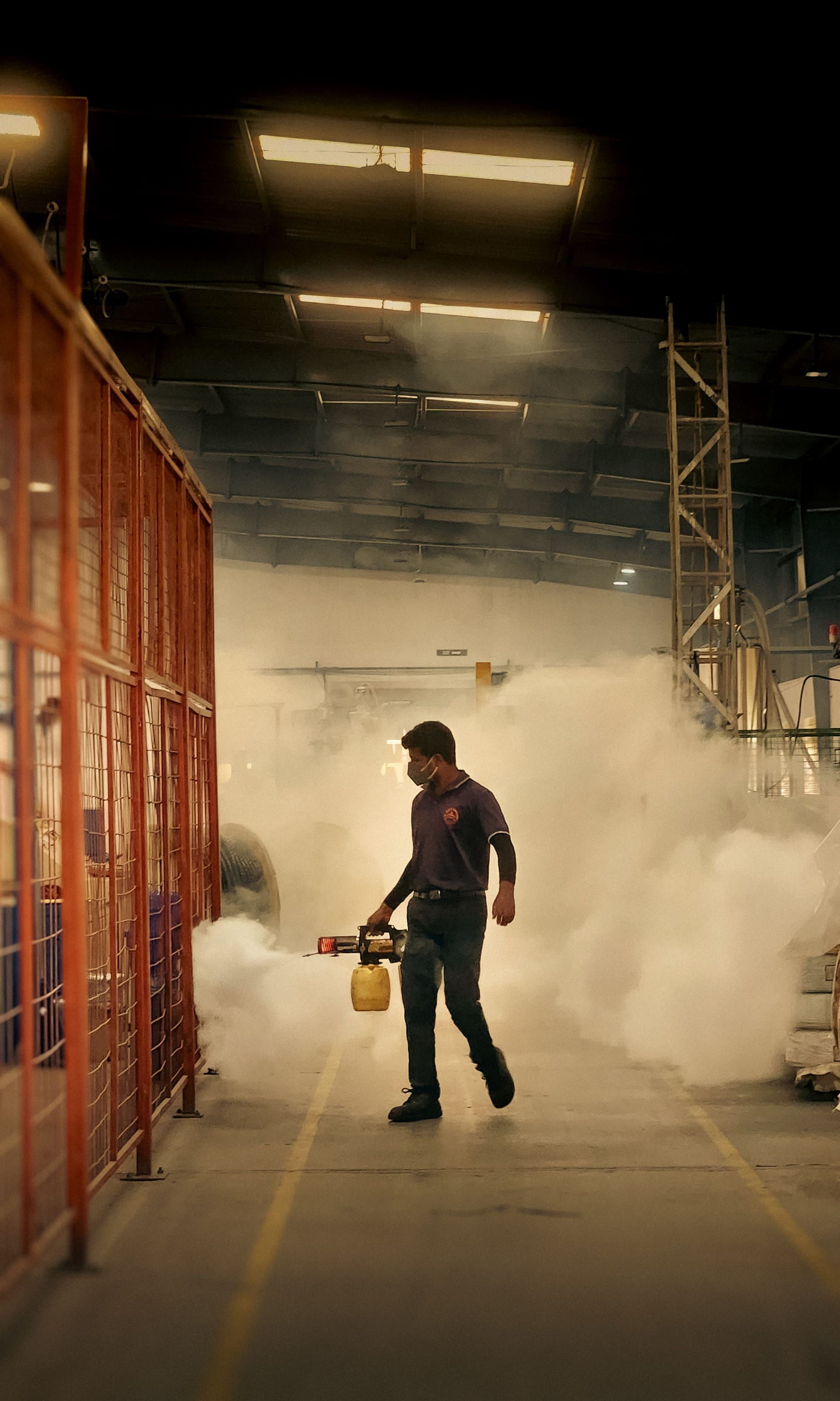 A worker fogging a storage hall for pest control
