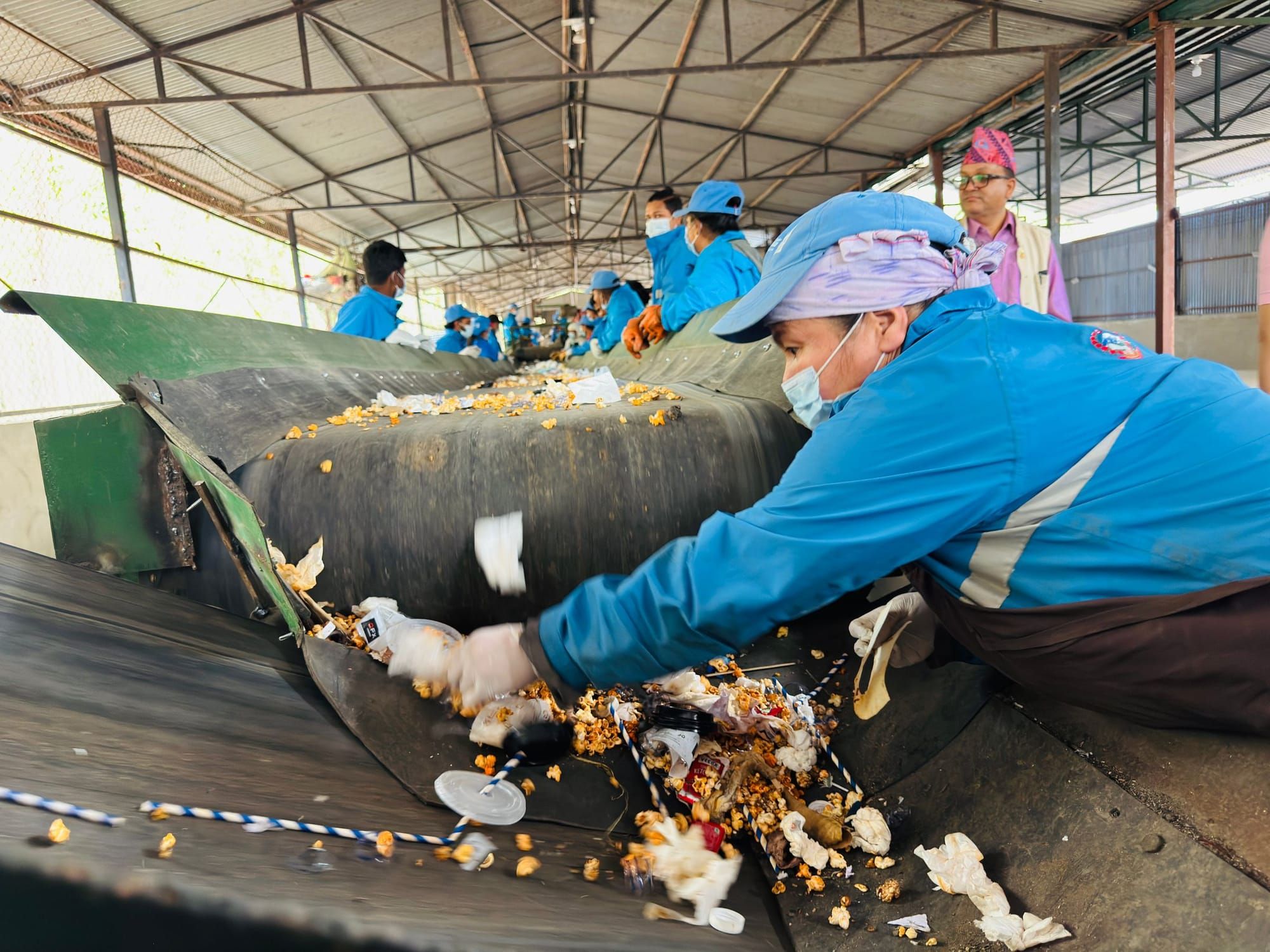 Workers sorting waste on a conveyor line