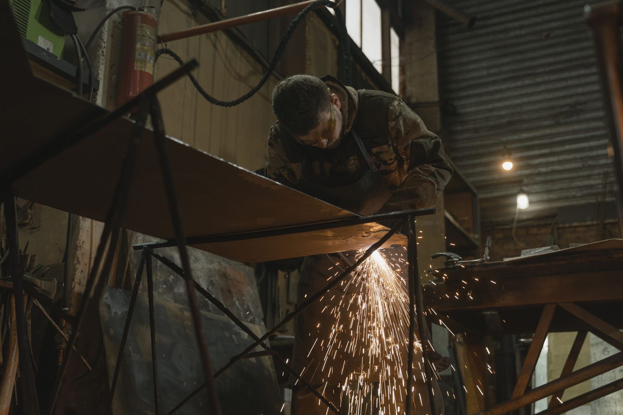 A worker welding a steel frame, sparks flying